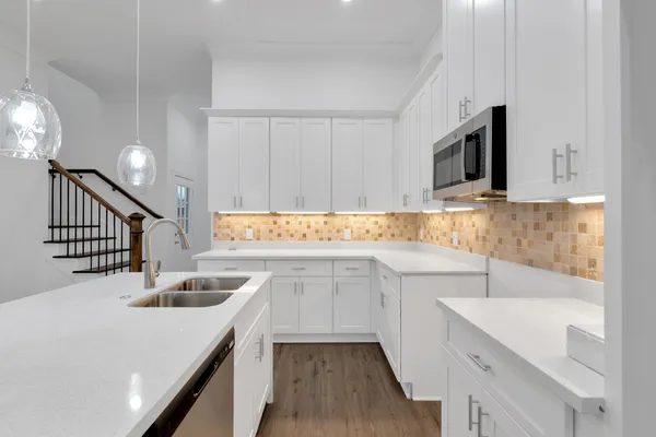 a kitchen with stainless steel appliances granite countertop a sink and dishwasher a stove top oven with wooden floor