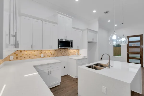 a kitchen with a sink and a stove top oven