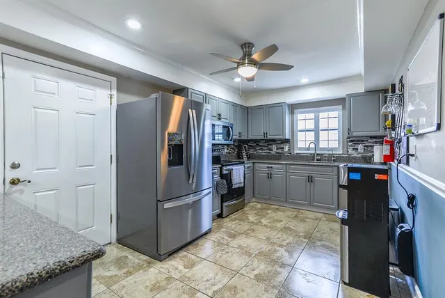 a kitchen with stainless steel appliances granite countertop a refrigerator and a sink