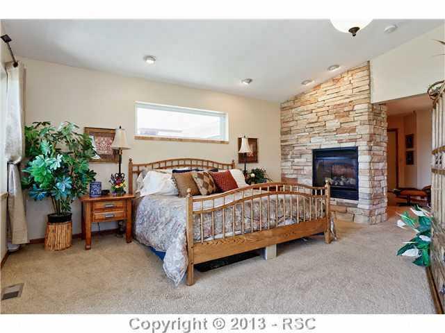 14575 Raton Road Colorado Springs, CO 80921 - Photo 11 of 25 Master Bedroom on main level is gorgeous with a sitting area, cultured stone doubled sided gas fireplace to the dressing area.