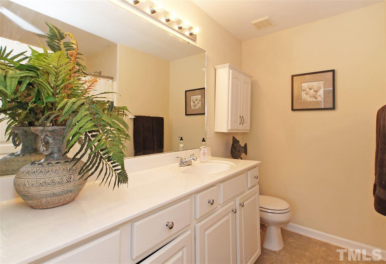 7822 Silverthread Lane Raleigh, NC 27617 - Photo 12 of 18 a bathroom with a sink a toilet and mirror