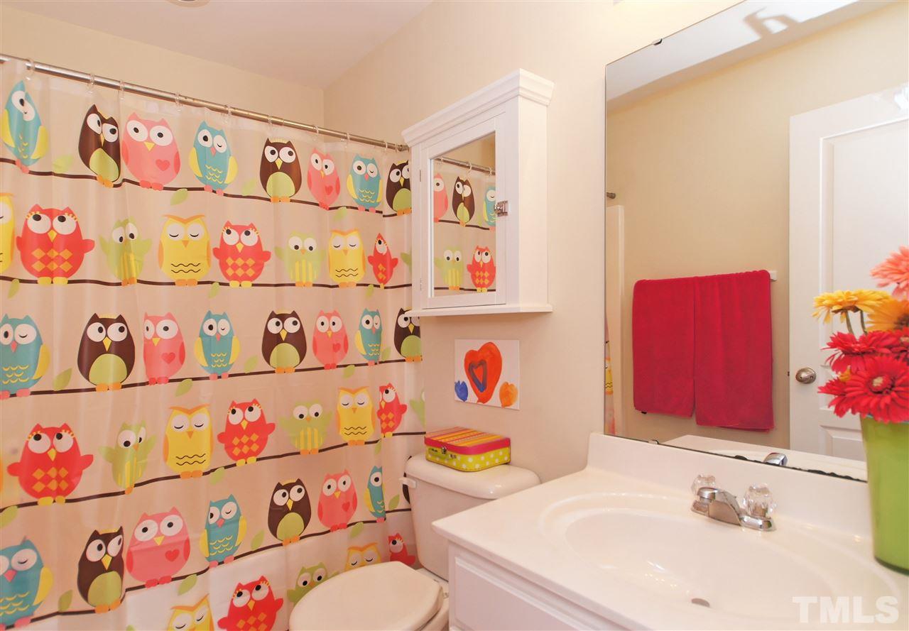 7822 Silverthread Lane Raleigh, NC 27617 - Photo 14 of 18 a bathroom with a sink a toilet and a shower curtain