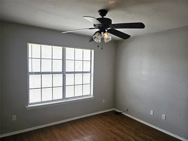 an empty room with a window and a fan