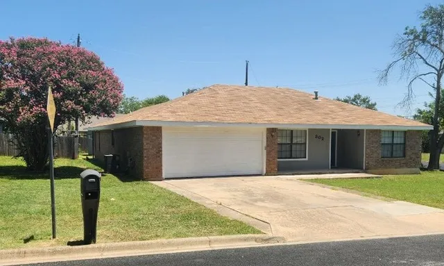 a front view of house with yard and trees
