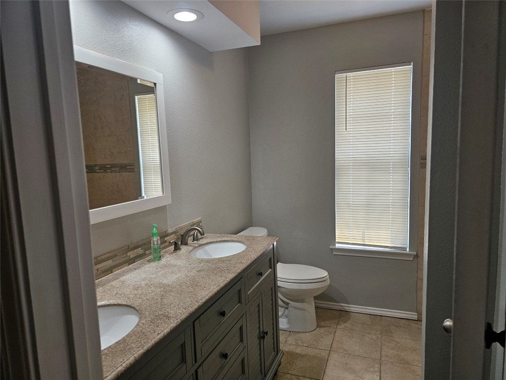 302 Burning Tree Drive Georgetown, TX 78628 - Photo 21 of 30 a bathroom with a granite countertop sink toilet and mirror