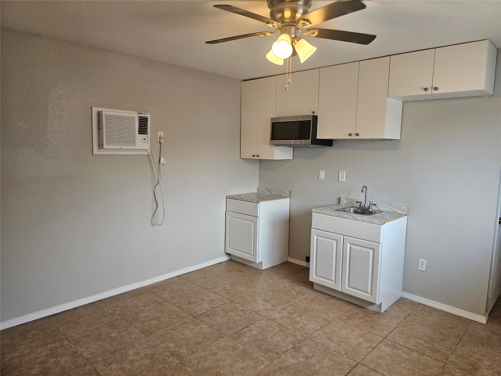302 Burning Tree Drive Georgetown, TX 78628 - Photo 24 of 30 a kitchen with granite countertop a sink a stove top oven and cabinetry