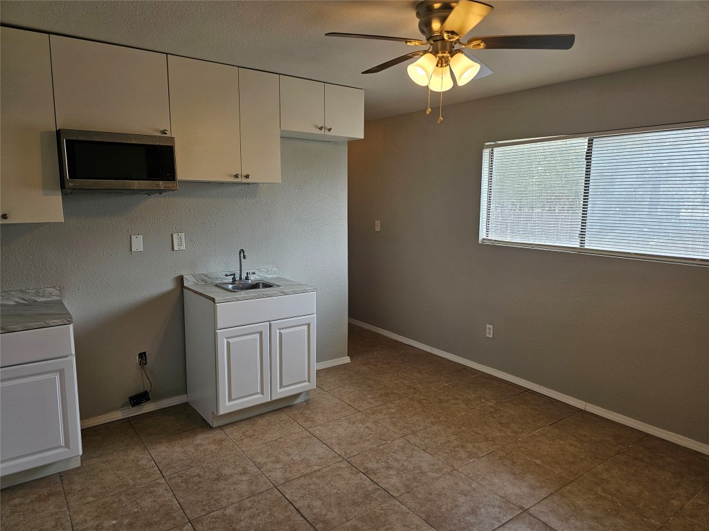 302 Burning Tree Drive Georgetown, TX 78628 - Photo 25 of 30 a kitchen with white cabinets appliances and a window