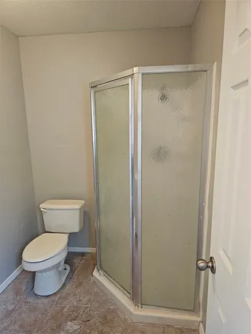 a white toilet sitting next to a shower