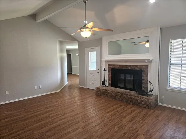 wooden floor fireplace and windows in an empty room