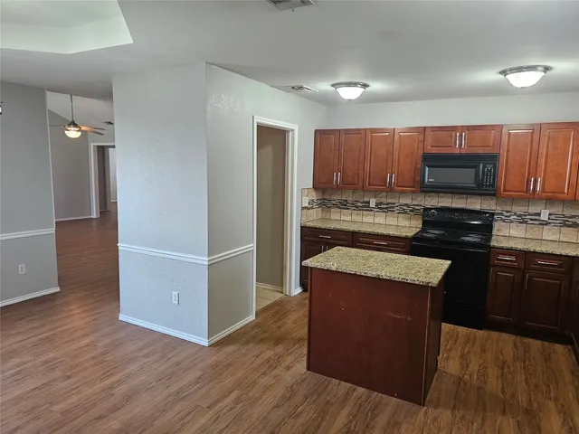 a kitchen with kitchen island wooden cabinets and stainless steel appliances
