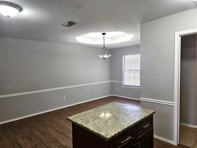 an empty room with wooden floor and window