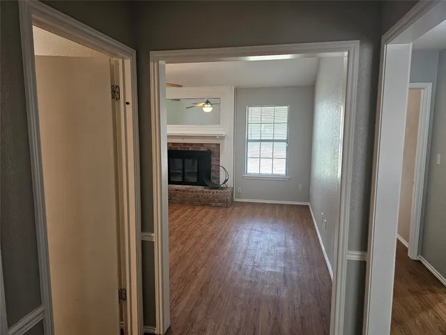 a view of empty room with wooden floor and fireplace