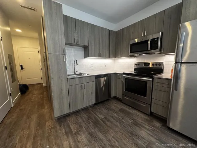 a kitchen with stainless steel appliances a stove a sink and a refrigerator