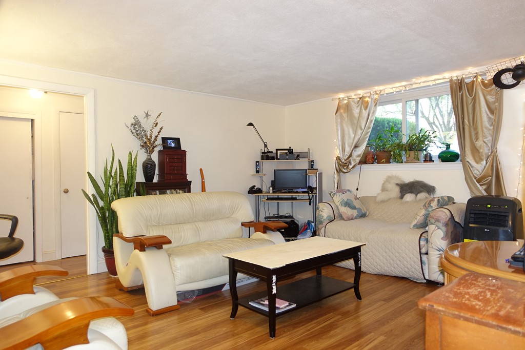 58 Bryon Road, Unit 2 Boston, MA 02467 - Photo 2 of 6 a living room with furniture a large window and wooden floor
