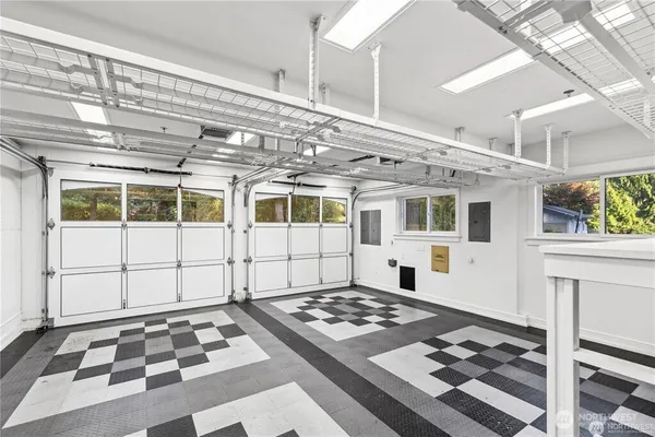 a large white bed in a white room next to a window
