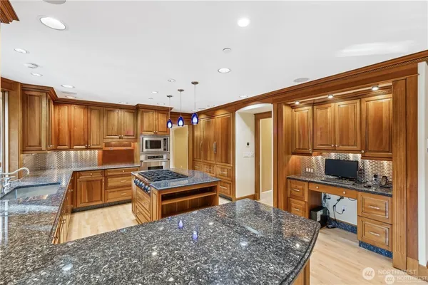 a kitchen with stainless steel appliances granite countertop a refrigerator stove and sink