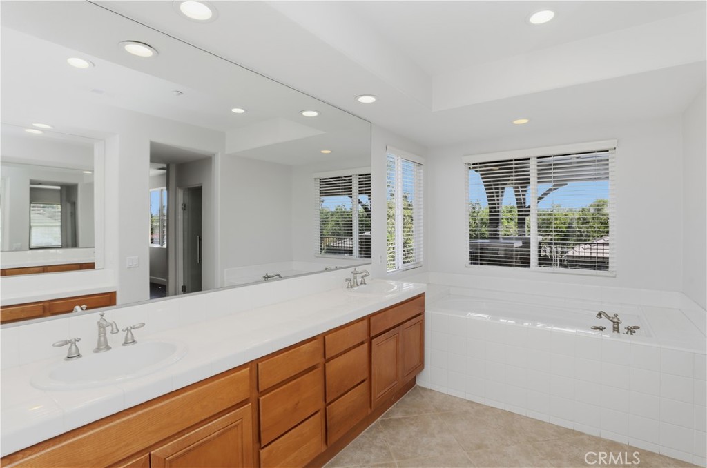 8075 Terraza Court Riverside, CA 92508 - Photo 21 of 75 a spacious bathroom with a double vanity sink a large mirror and a bathtub