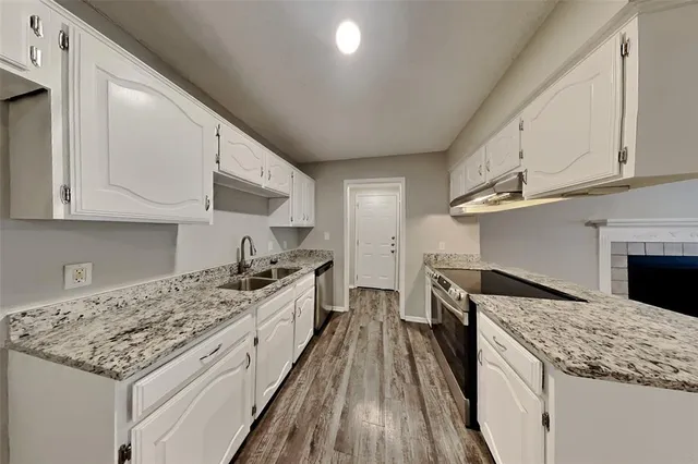 a kitchen with granite countertop kitchen island wooden cabinets and stainless steel appliances