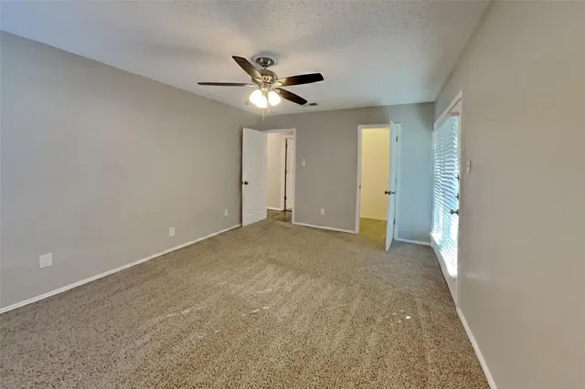 an empty room with closet and windows