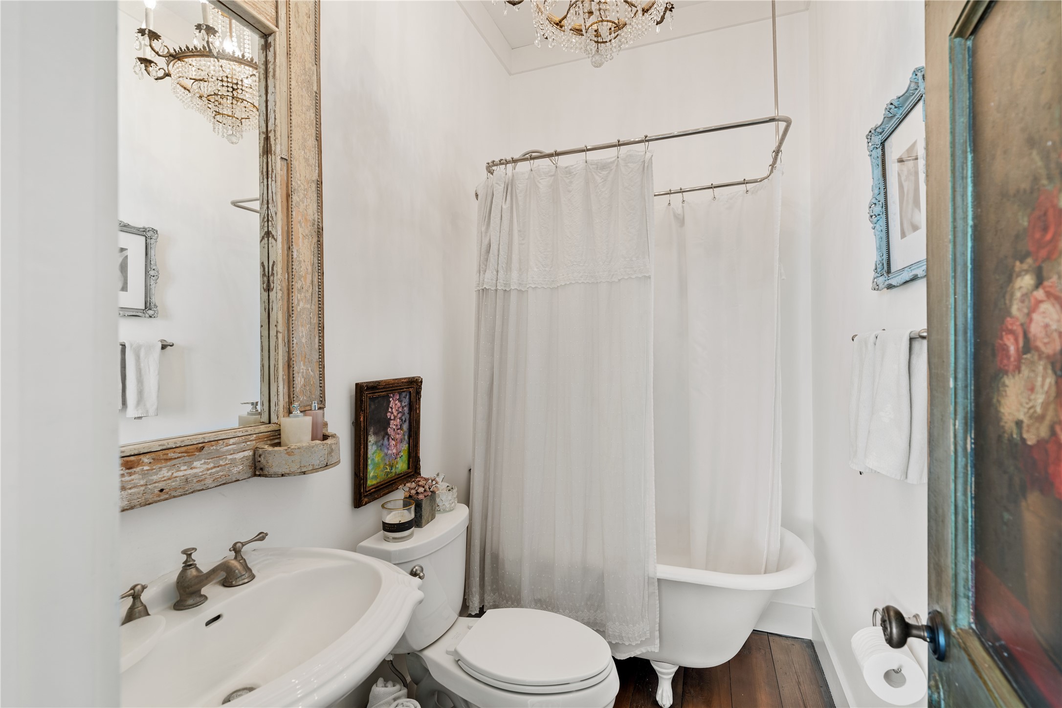 5025 Wickel Road Burton, TX 77835 - Photo 18 of 50 This ensuite bathroom features a charming vintage design with a clawfoot tub, antique chandelier, hardwood floors.