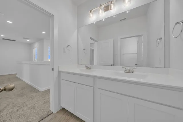 a bathroom with double sink and a mirror