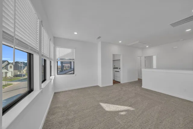 a view of an empty room with a fireplace and window