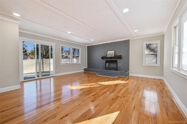 a view of empty room with wooden floor and window