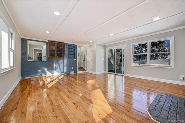 a big room with wooden floor and windows