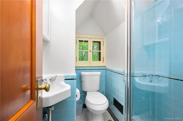 a bathroom with a granite countertop toilet a sink and a mirror