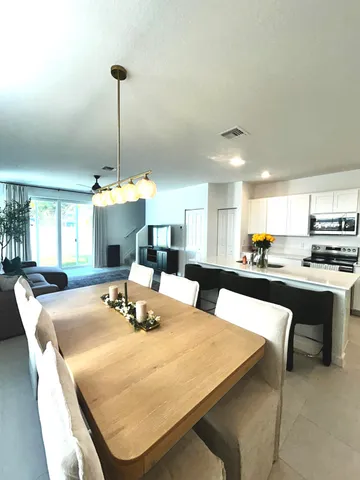 a kitchen with stainless steel appliances a sink a stove a refrigerator with white cabinets