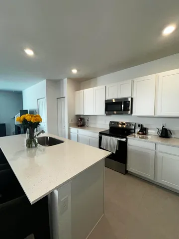 a large kitchen with a sink and cabinets