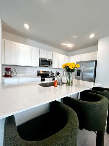 a kitchen with stainless steel appliances granite countertop a sink a stove and a refrigerator