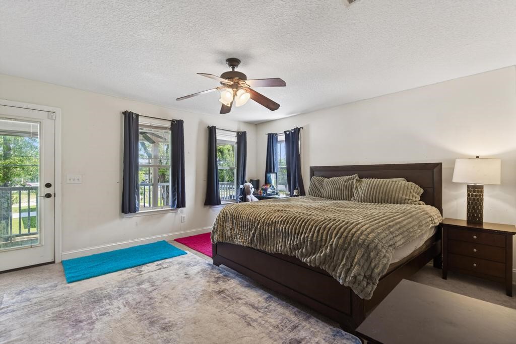 45107 Booth Street Callahan, FL 32011 - Photo 37 of 68 a bedroom with a large bed and a chandelier fan