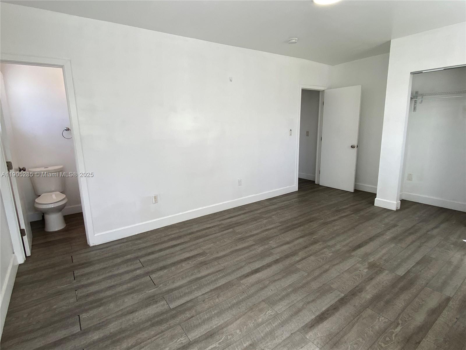 9025 Harding Avenue, Unit 1 Surfside, FL 33154 - Photo 14 of 25 a view of an empty room with wooden floor and a toilet