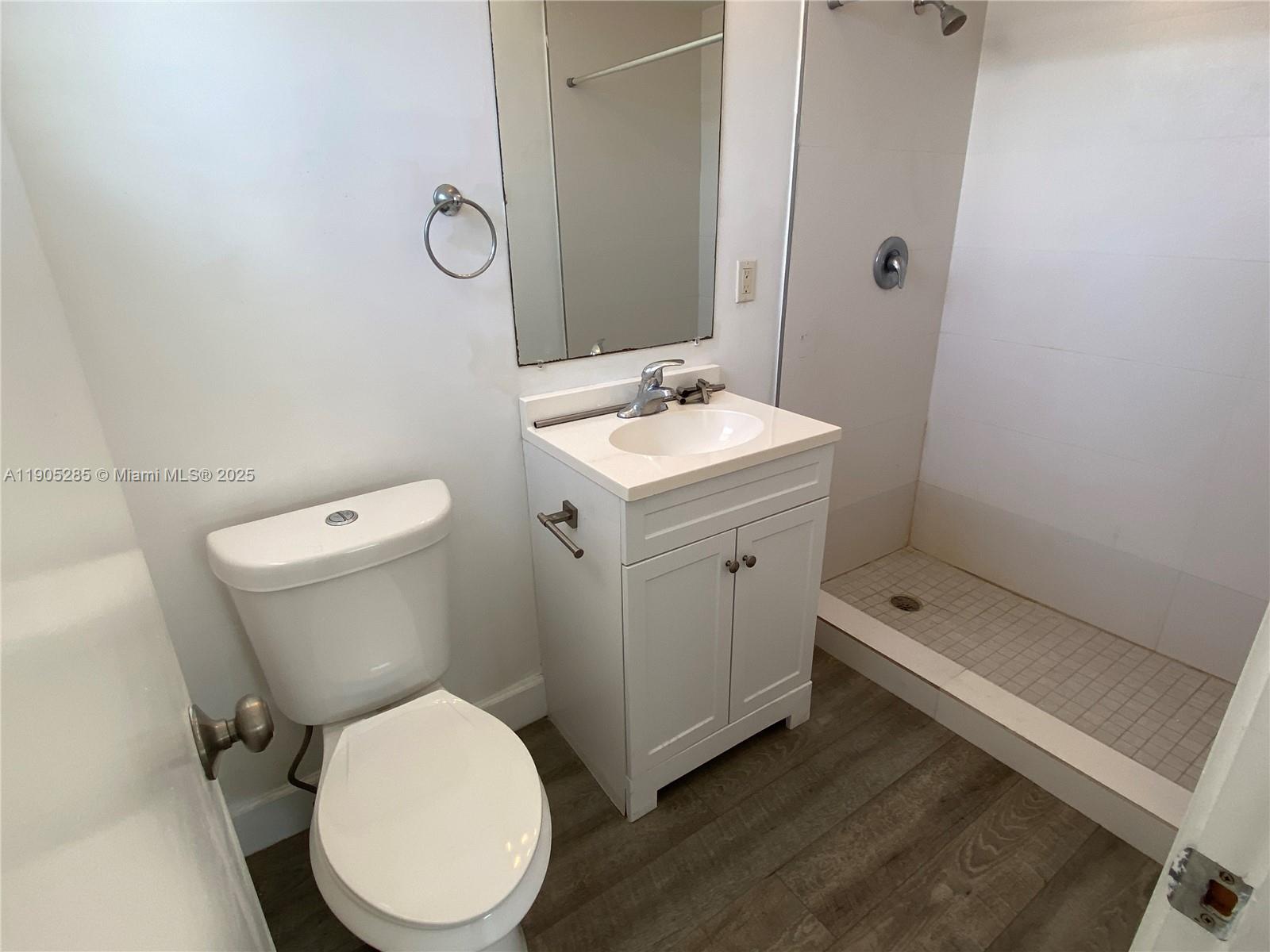 9025 Harding Avenue, Unit 1 Surfside, FL 33154 - Photo 15 of 25 a bathroom with a toilet sink and mirror