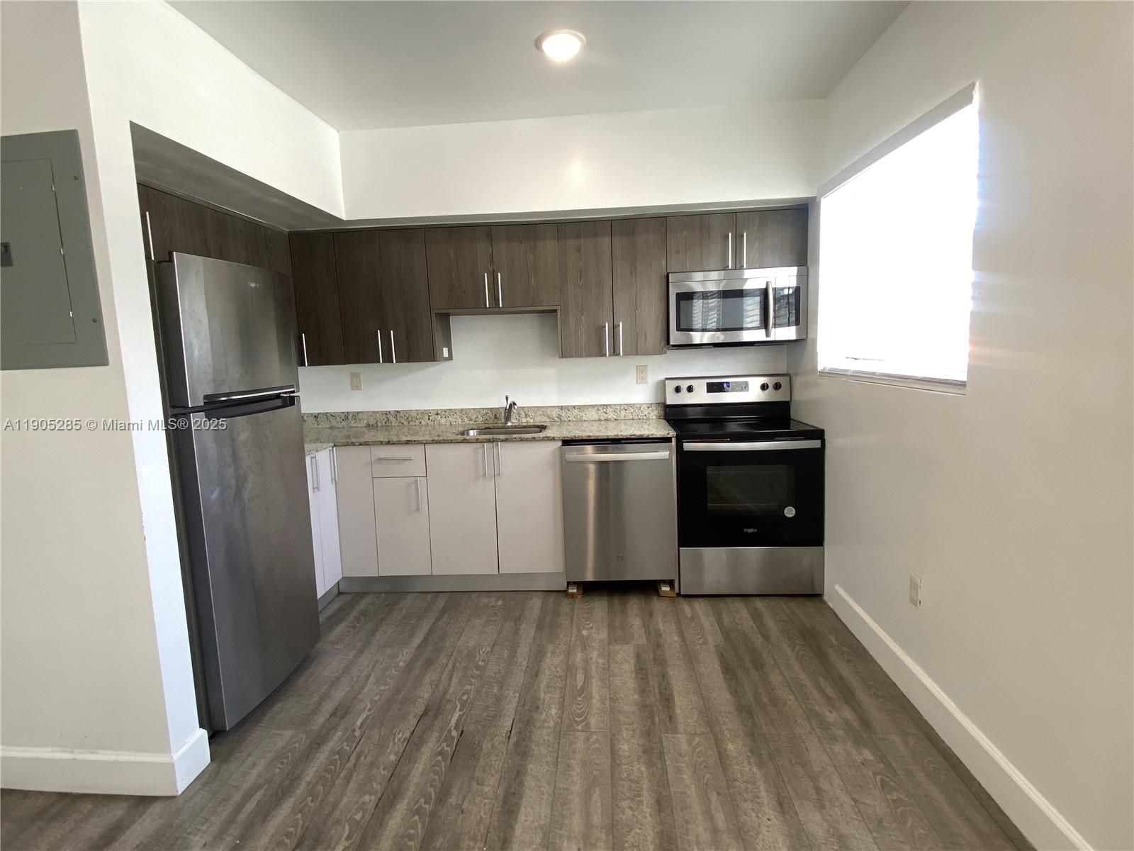 9025 Harding Avenue, Unit 1 Surfside, FL 33154 - Photo 6 of 25 a kitchen with stainless steel appliances a sink a stove a refrigerator and cabinets