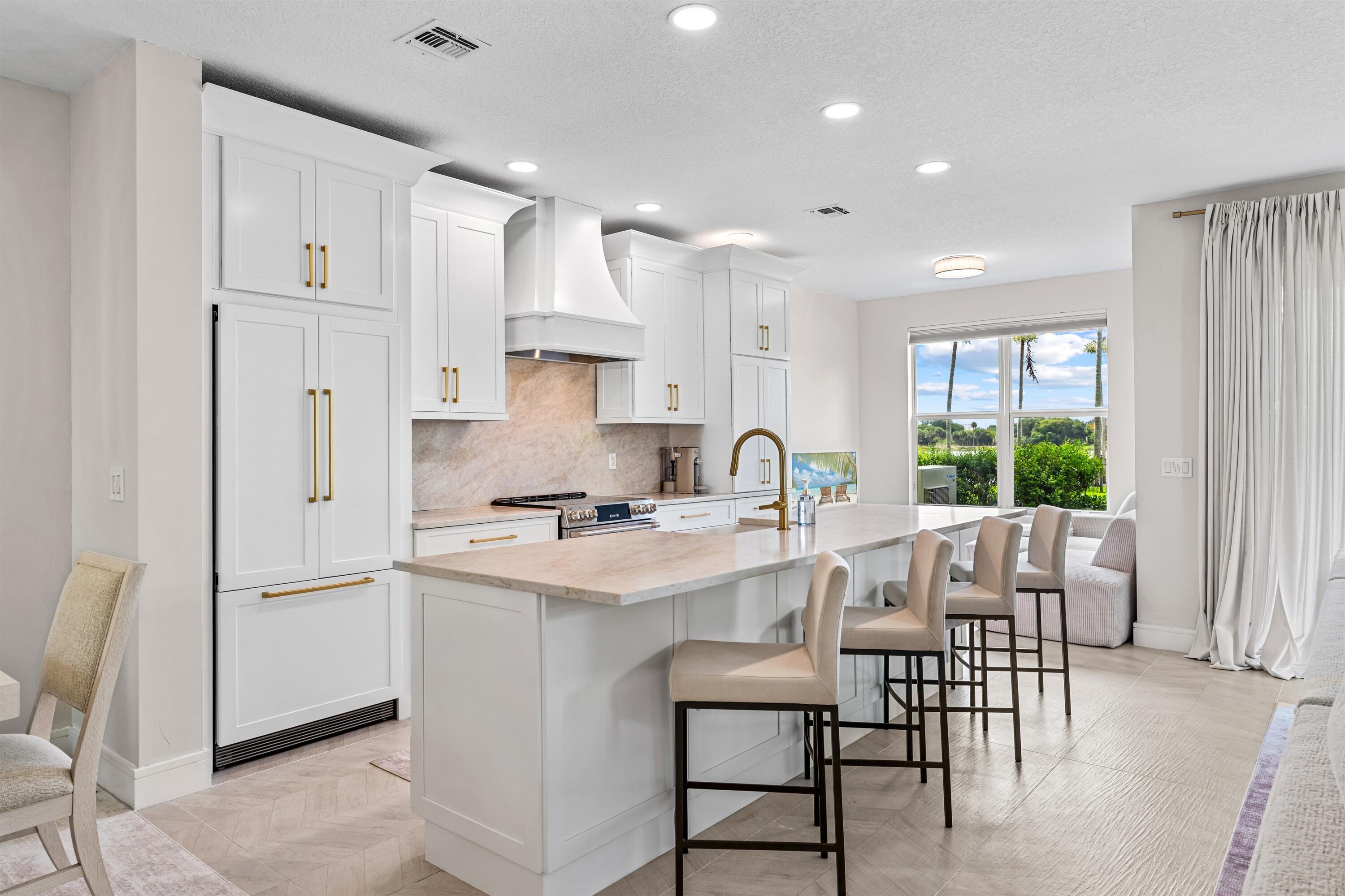 1570 Northwest 48th Place Boca Raton, FL 33431 - Photo 6 of 30 a kitchen with white cabinets and stainless steel appliances