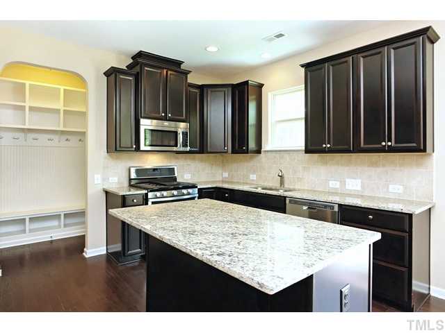 2426 Pilsley Road Apex, NC 27539 - Photo 7 of 25 a kitchen with stainless steel appliances granite countertop a stove refrigerator and cabinets