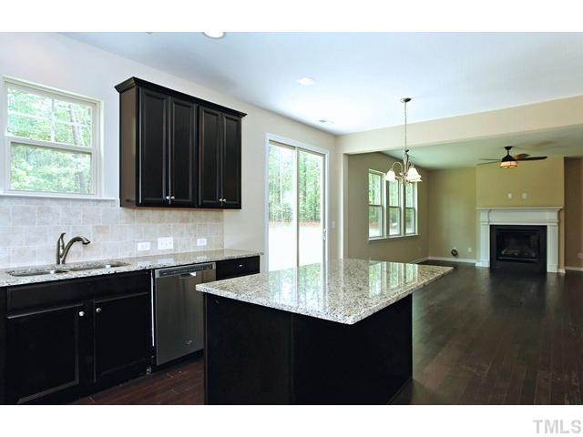 2426 Pilsley Road Apex, NC 27539 - Photo 8 of 25 a kitchen with granite countertop a sink cabinets and wooden floor