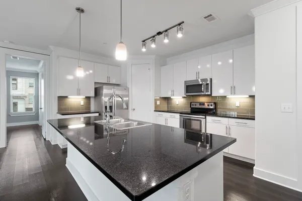 a kitchen with stainless steel appliances granite countertop a sink a center island and stainless steel appliances