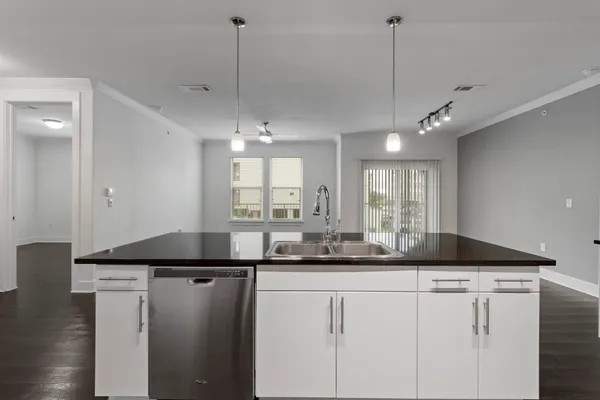 a kitchen with kitchen island granite countertop a sink a counter space appliances and cabinets