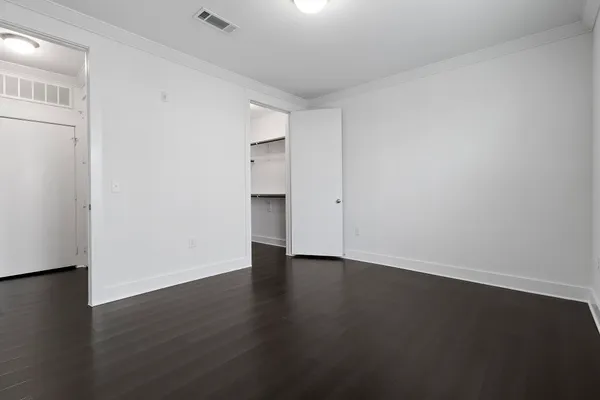 a view of an empty room with wooden floor