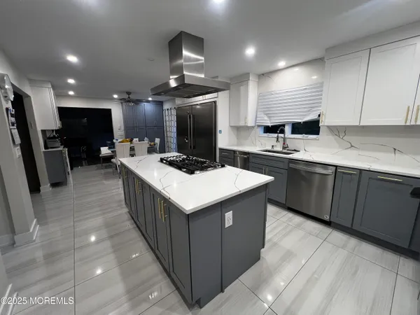 a kitchen with a refrigerator a sink and black cabinets
