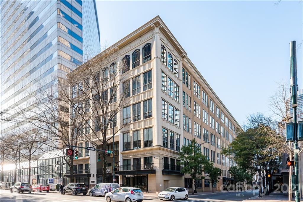 127 North Tryon Street, Unit 416 Charlotte, NC 28246 - Photo 2 of 24 a front view of a building with lot of cars and trees