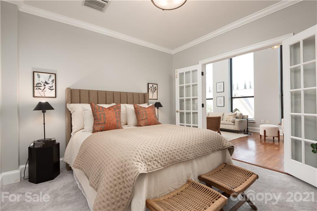 127 North Tryon Street, Unit 416 Charlotte, NC 28246 - Photo 16 of 24 a bedroom with a bed and wooden floor