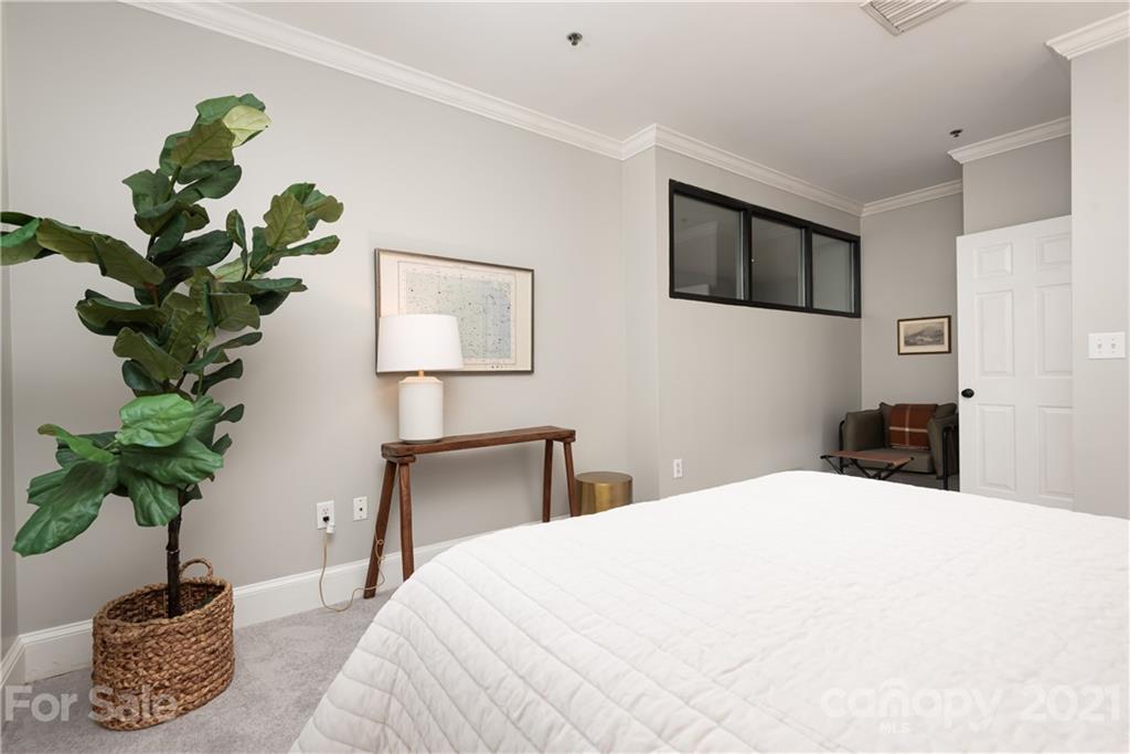 127 North Tryon Street, Unit 416 Charlotte, NC 28246 - Photo 19 of 24 a bedroom with a bed and a potted plant