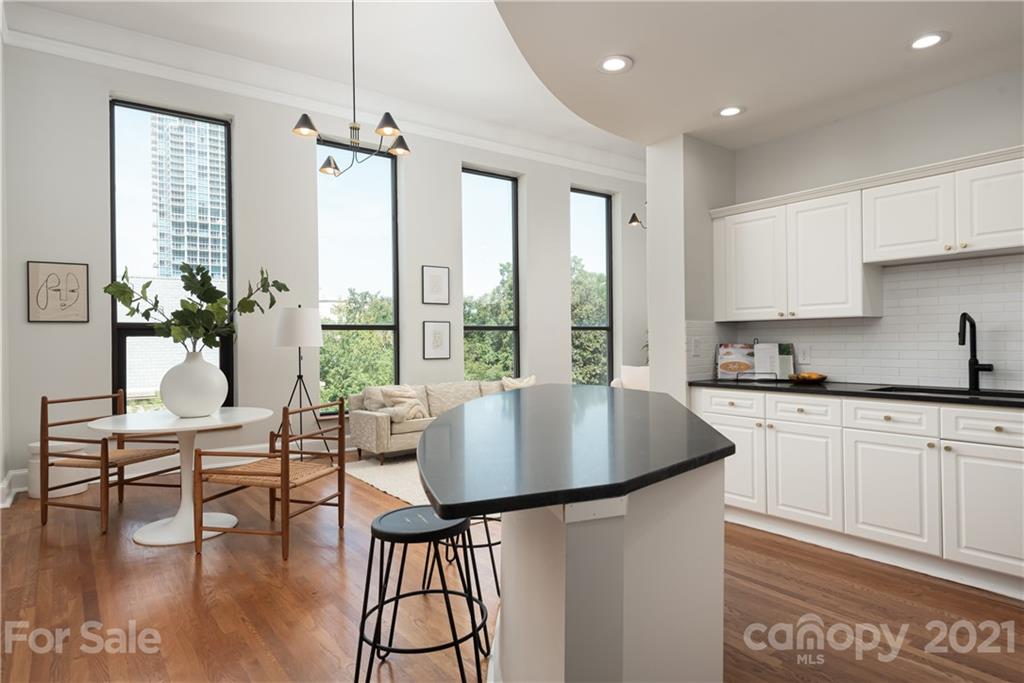 127 North Tryon Street, Unit 416 Charlotte, NC 28246 - Photo 5 of 24 a kitchen with a table chairs stove and cabinets