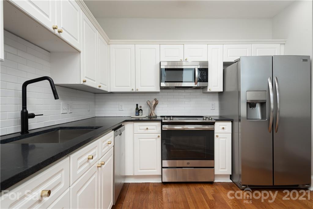 127 North Tryon Street, Unit 416 Charlotte, NC 28246 - Photo 6 of 24 a kitchen with stainless steel appliances granite countertop a refrigerator sink and white cabinets