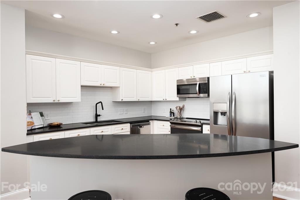 127 North Tryon Street, Unit 416 Charlotte, NC 28246 - Photo 7 of 24 a kitchen with stainless steel appliances granite countertop a sink a stove and a refrigerator