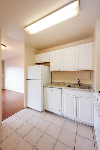 a kitchen with white cabinets and white appliances